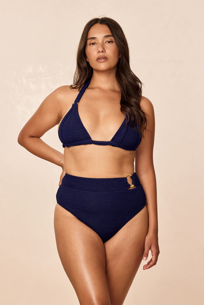 Front of Morocco Top in Midnight Crinkle, textured navy halter triangle with narrow underbust band on model, neutral backdrop