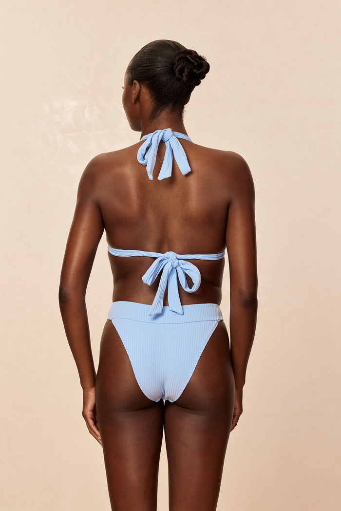 Back view of Marseille Bottom in Sky Rib showing ribbed fabric, high-leg cut and cheeky coverage on a beige studio background