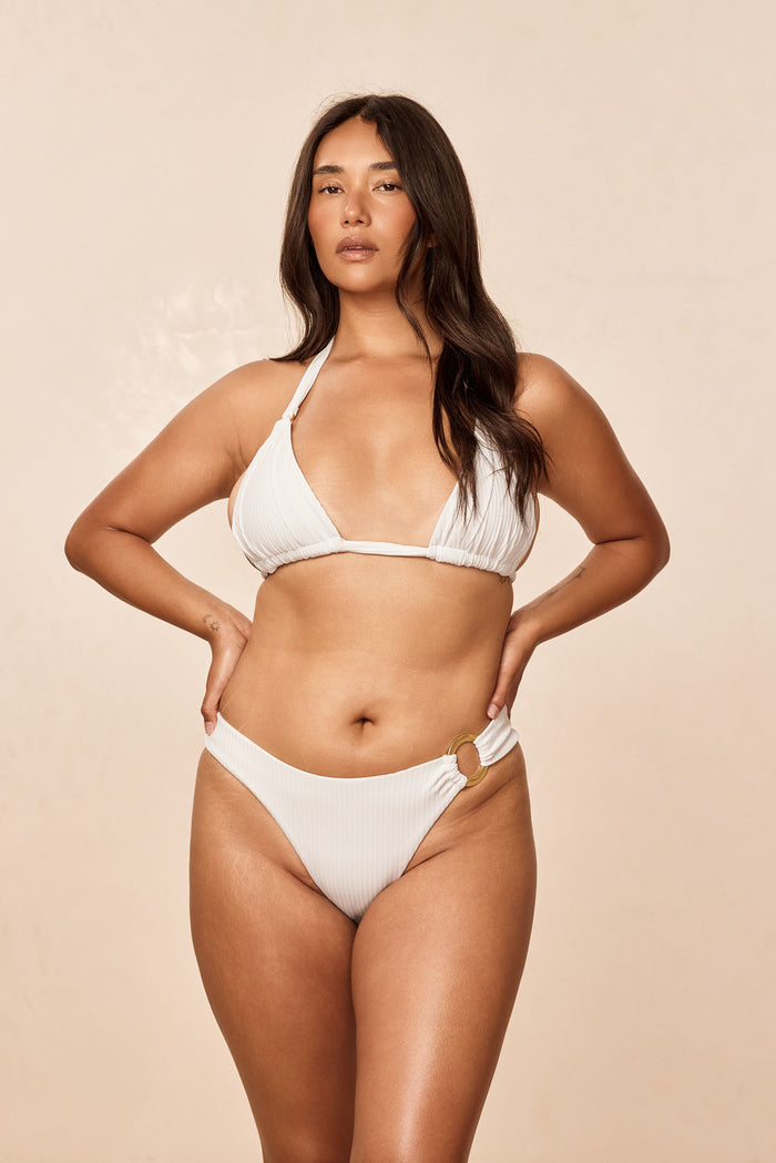 Front view of Morocco Top Optic White rib showing pleated cups, gold ring detail and adjustable neck and back ties on model