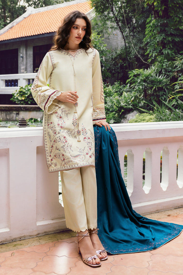 Woman in a cream embroidered kurta with blue dupatta on a balcony