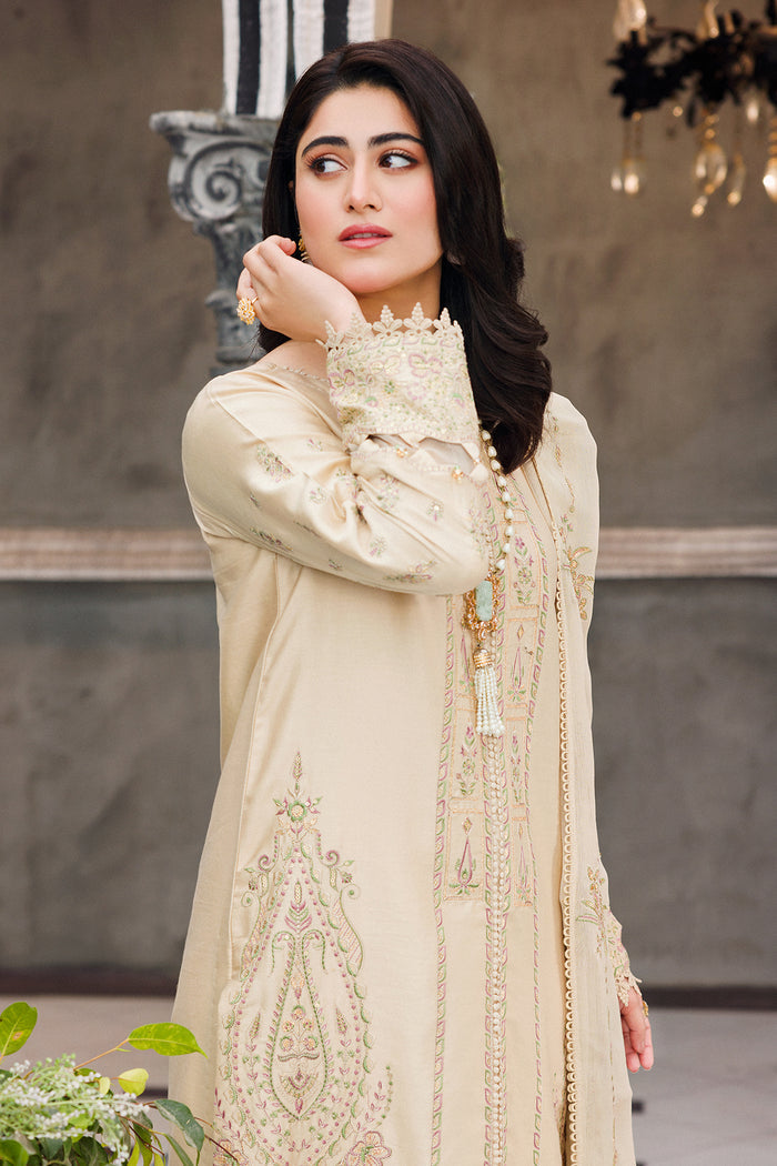 Side portrait showing neckline embroidery and sleeve detailing of skin gold dress