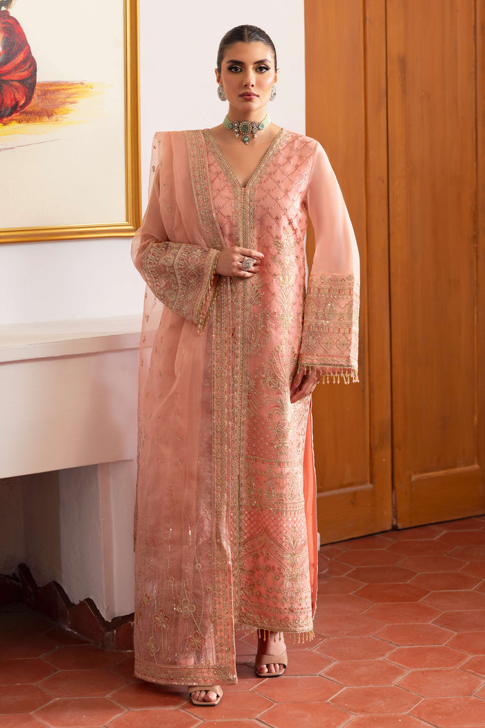 NAQSHI Muzna flamingo‑pink organza gown‑style shirt with V‑neckline, heavy Islamic‑Mughal embroidery, sequin lace panels, mid‑slit and matching straight‑cut silk trousers.