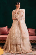 Naqshi Nigaar beige‑pink organza long shirt with boat neckline and dangling crystal tassels on sleeves and sides, paired with heavily embroidered sequin‑work lehenga and ornate dupatta.