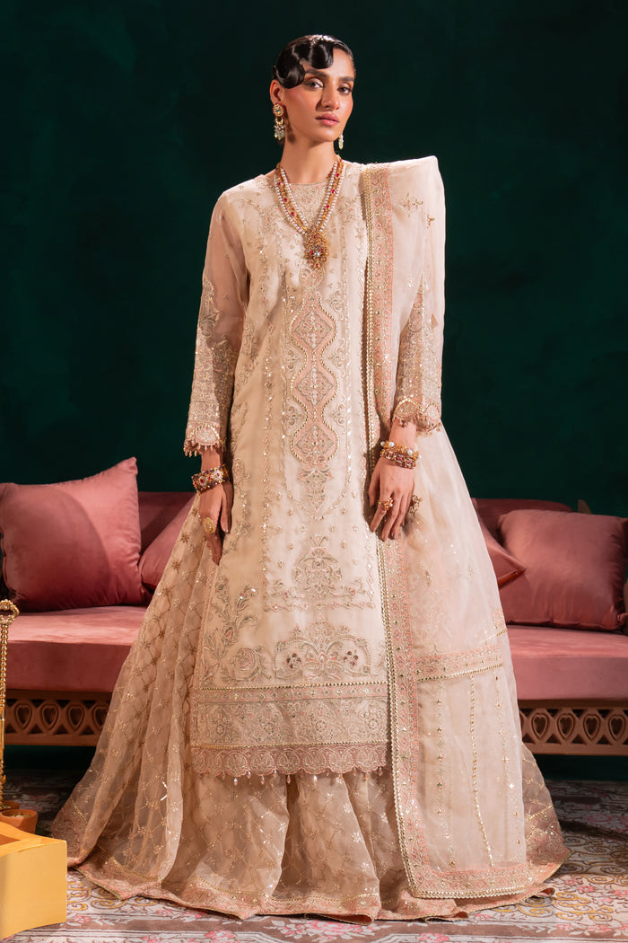 Side view of Naqshi Nigaar showcasing voluminous lehenga flare, scalloped embroidered hem, and crystal-dangling sleeve embellishments on organza shirt.