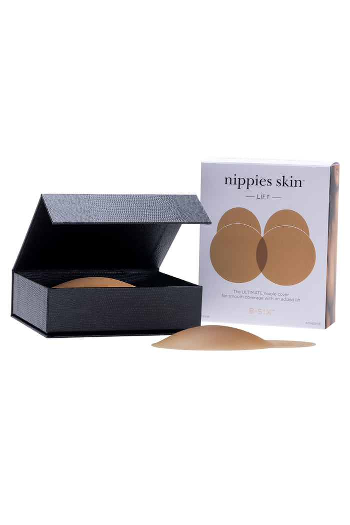 Front view of Nippies Skin Lift tan silicone nipple covers showing domed lift and included black storage box on white background