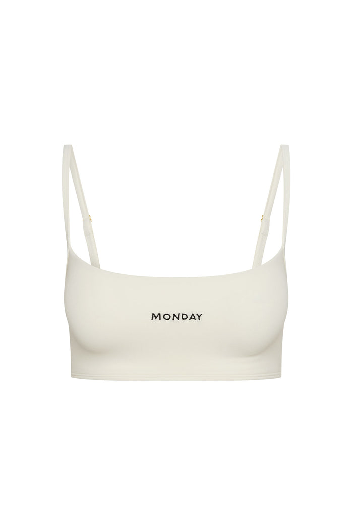 Ivory crop bra with thin adjustable straps and MONDAY embroidered at center front.