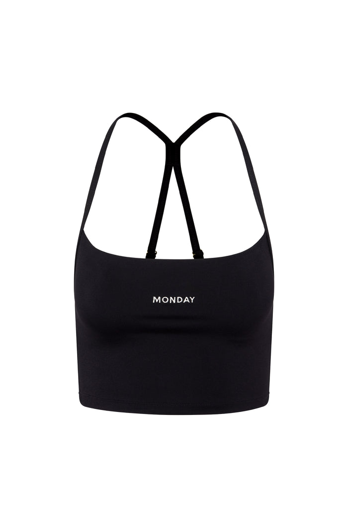 Black cropped tank top with thin crossed back straps, 'MONDAY' embroidered on front.