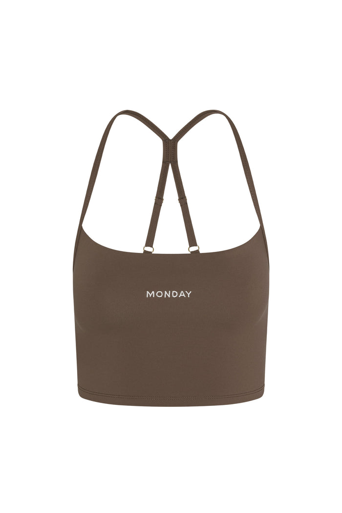 Front view of Olympic Tank in stone showing scoop neckline, built-in shelf bra, adjustable racerback straps and "MONDAY" embroidery on white background