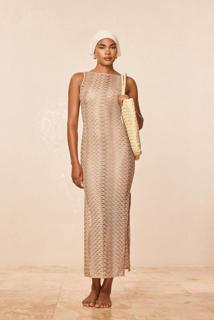 Front of Oslo Dress in Porto Cervo Gold, fitted crochet knit with high boat neck and sleeveless, worn by model on beige backdrop