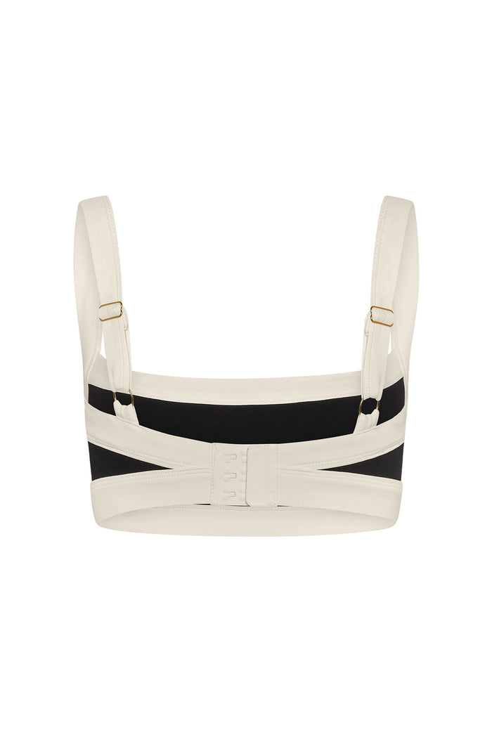 Ivory bra back view with adjustable straps, black back panel and three-row hook-and-eye closure.
