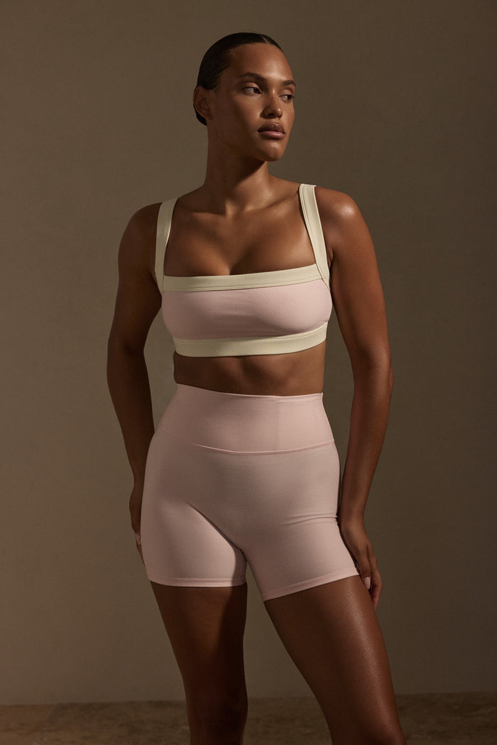 Three-quarter front of Outpost Bra in heather powder pink/ivory with straight neckline and adjustable straps