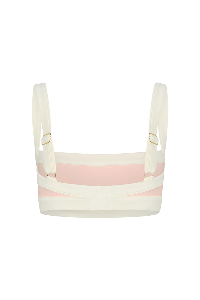 Back view of Outpost Bra in heather powder pink and ivory showing adjustable straps and three-hook back closure on white background