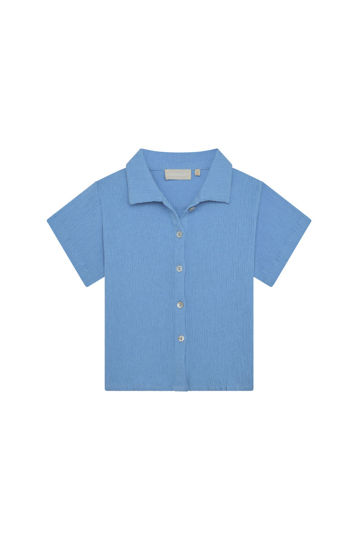 Front view of Pacific Beach kids short-sleeve button-up shirt in Azure Crinkle showing camp collar, buttons, and crinkled rayon-linen texture on white background