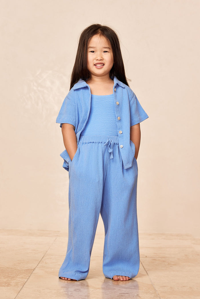 Front view of Pacific Beach Shirt Kids in Azure Crinkle showing short-sleeve button-front crinkle fabric on beige background