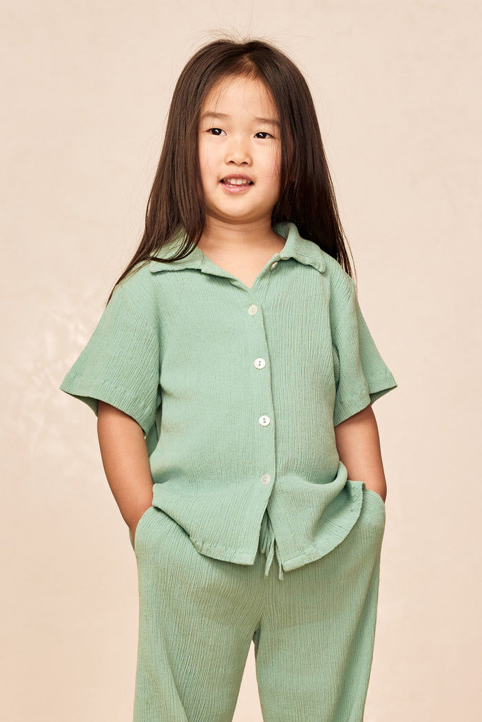 Front of Pacific Beach Shirt Kids in Pond Crinkle showing crinkled texture, short sleeves, button front, relaxed fit on model