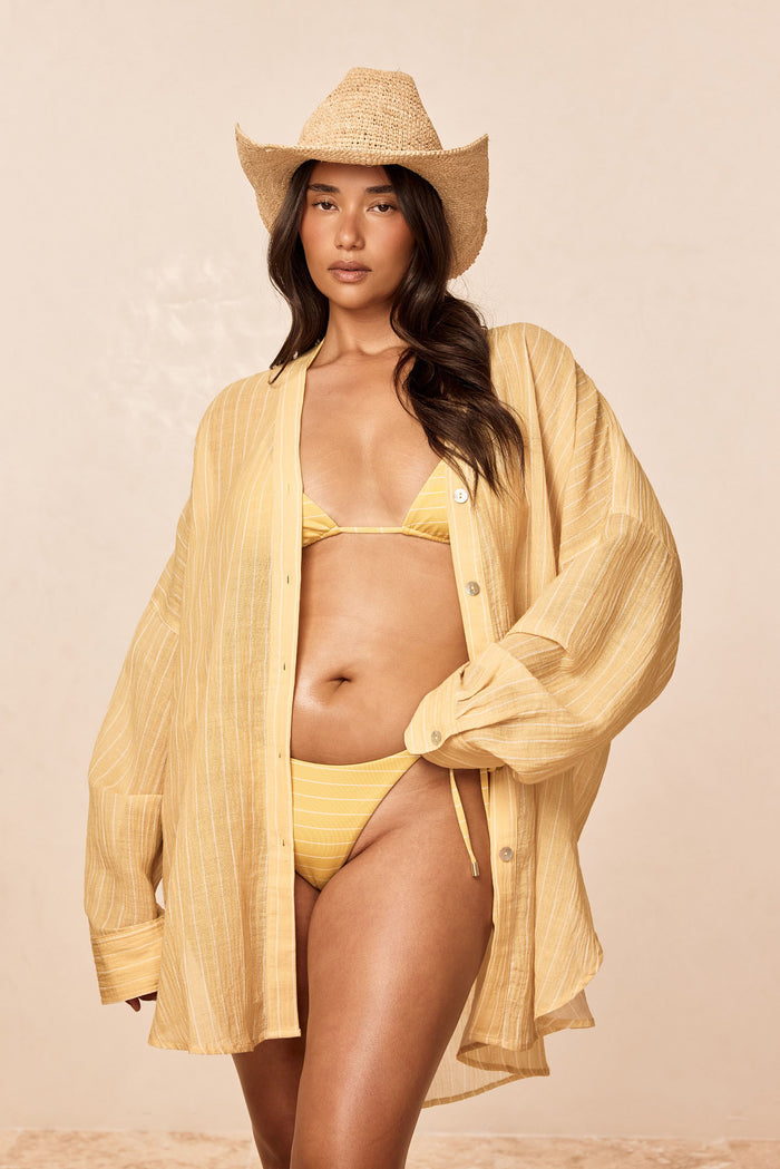 Front view of Palma Bottom - Meyer Stripe on model showcasing adjustable side ties and gold hardware with beige studio background