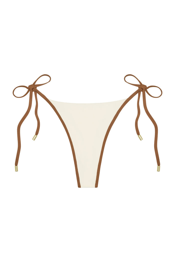 Front view of Palma Thong showing ivory color block panel with caramel brown trim and tie-side straps with gold tips on white background