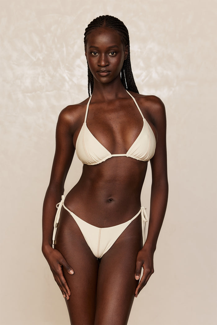 Front view of Palma Top in Champagne Denim on model showing triangle cups with adjustable halter ties on neutral background