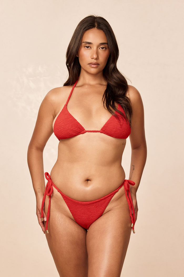 Front view of Palma Top in Chili Pepper crinkle showing triangle bikini cups and braided halter straps on model against a beige background