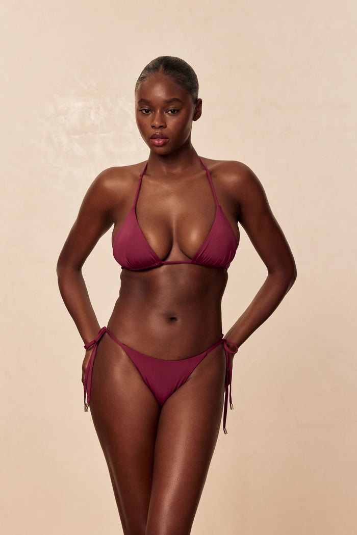Front view of Palma Top in fig on model showing triangle cups, removable padding, and adjustable neck and back ties