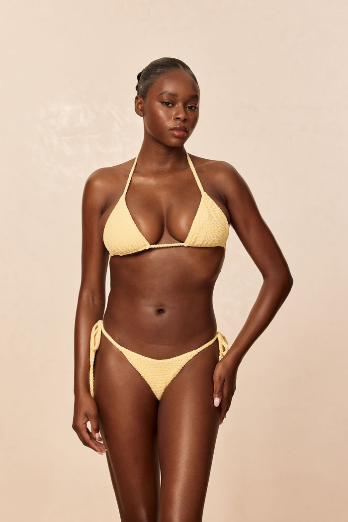 Front view of Palma Top in Honey Crinkle on model, triangle halter cups with adjustable neck tie and crinkle texture