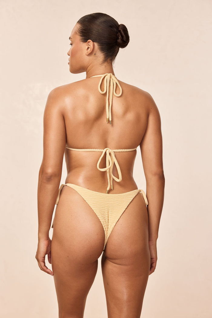 Rear view of Palma Top in Raffia Crinkle showing tie back straps and textured crinkle fabric on a neutral beige background