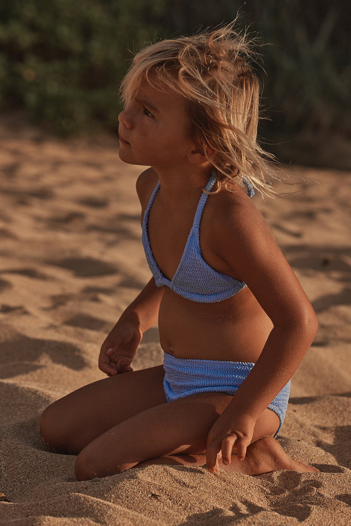 Side view of Palma Top & Seychelles Bottom Set in Pool Crinkle showcasing crinkle texture and halter top on a sandy beach