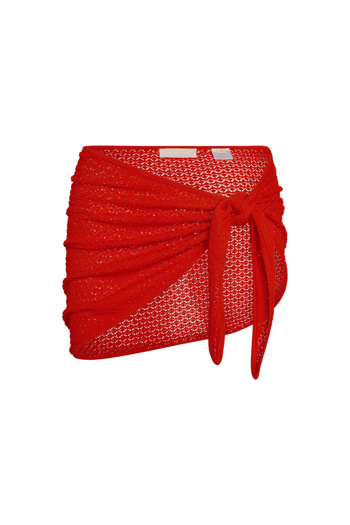 Front close-up of Paris Sarong in Chili Pepper lace crochet showcasing tied hip knot and sheer unlined crochet knit on white background