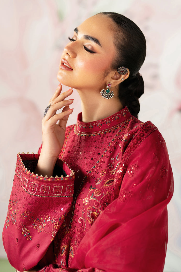 Portrait close up highlighting embroidered V neckline band collar detailing on red ready to wear suit