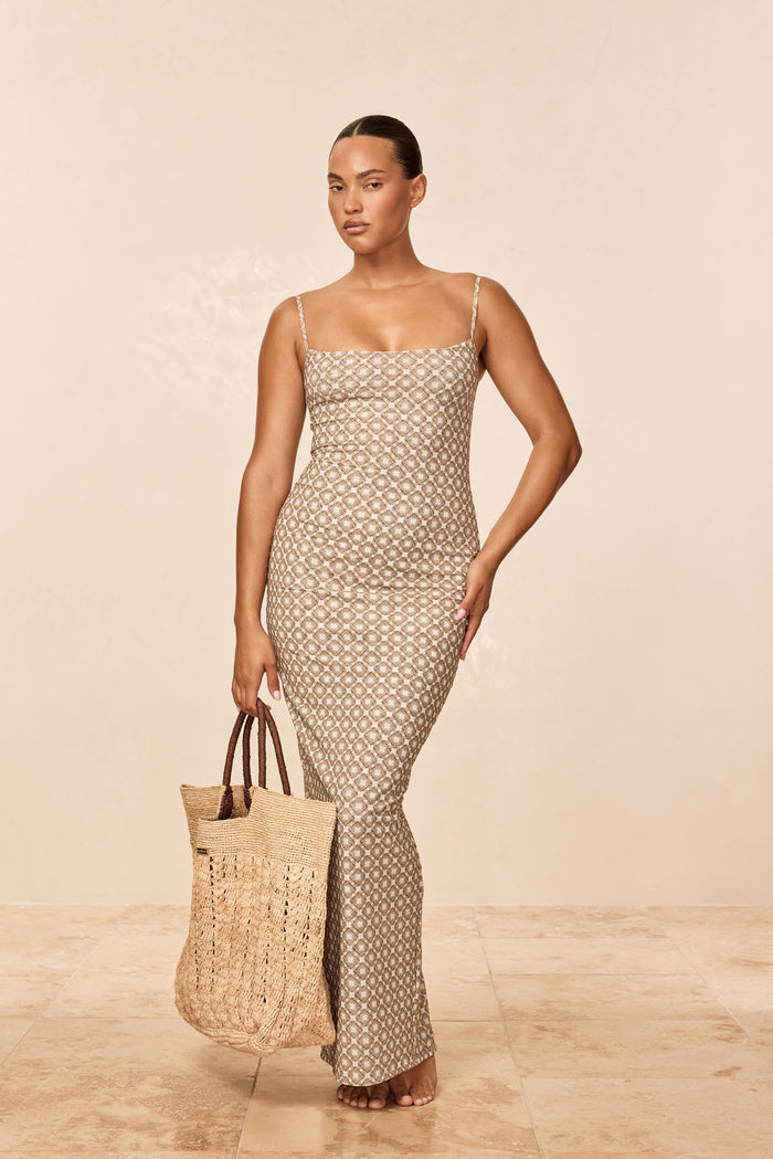 Front full-length of Provence dress in Tile Geo mesh showing square neckline, thin straps and fitted ankle-length silhouette on beige background