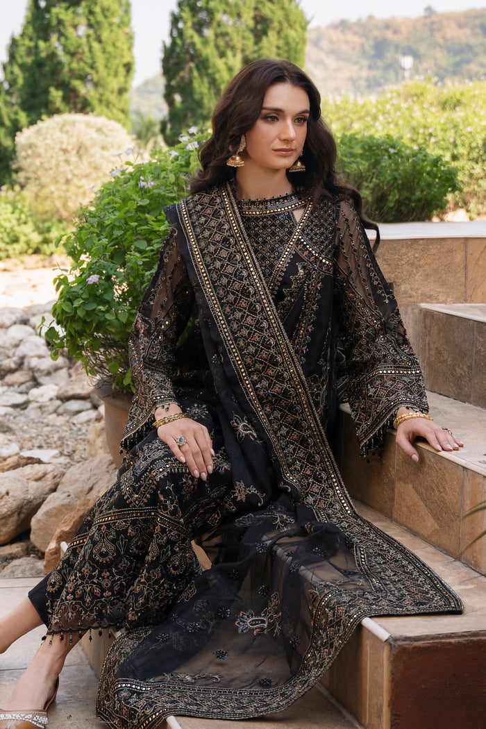 Seated front view of NAQSHI Qirat black organza outfit highlighting keyhole neckline, beadwork, and rich embroidered details.