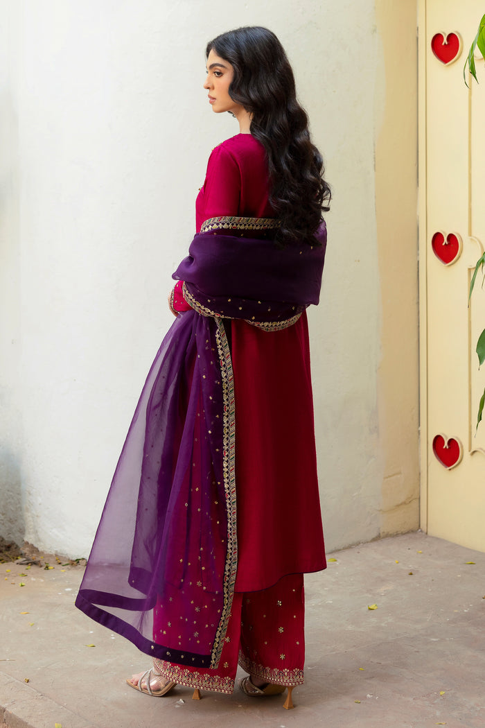 Model wearing full NAQSHI Raima 3PC: hand-adda embellished hot-pink raw silk shirt, sequin-embroidered culottes & purple-hued organza dupatta for rich, festive appeal.