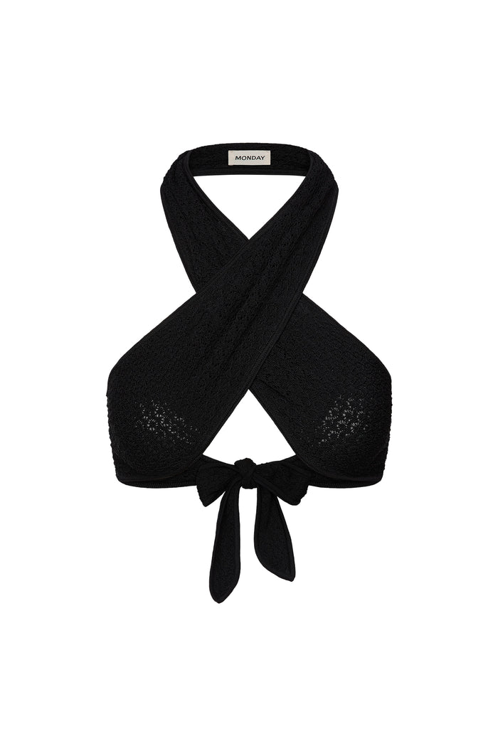 Front view of Ramatuelle Top in Black Lace Crochet showing crossed halter straps, wrap tie front and lace texture on white