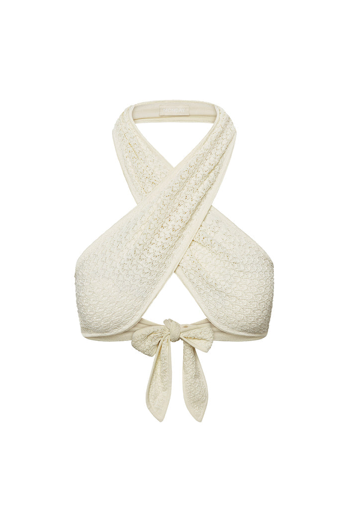 Front close up of Ramatuelle Top in ivory lace crochet showing crisscross halter wrap and tied bow on white background