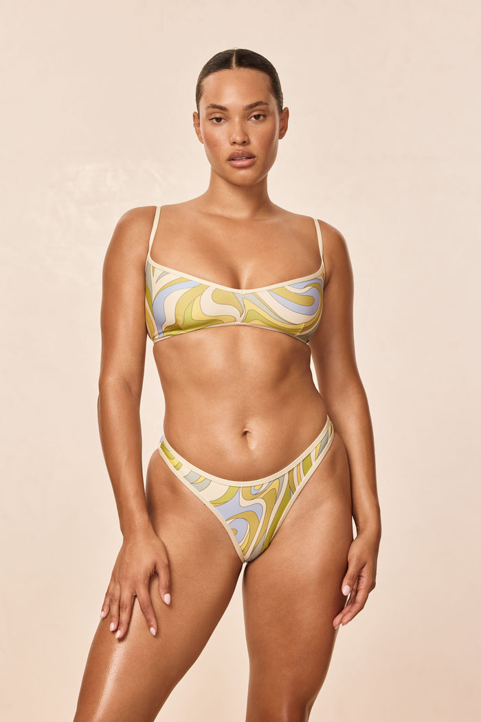 Front of Ravello Top in Costa Rei Apple and Ivory, scoop bralette with thin straps and swirled green and blue print on beige background