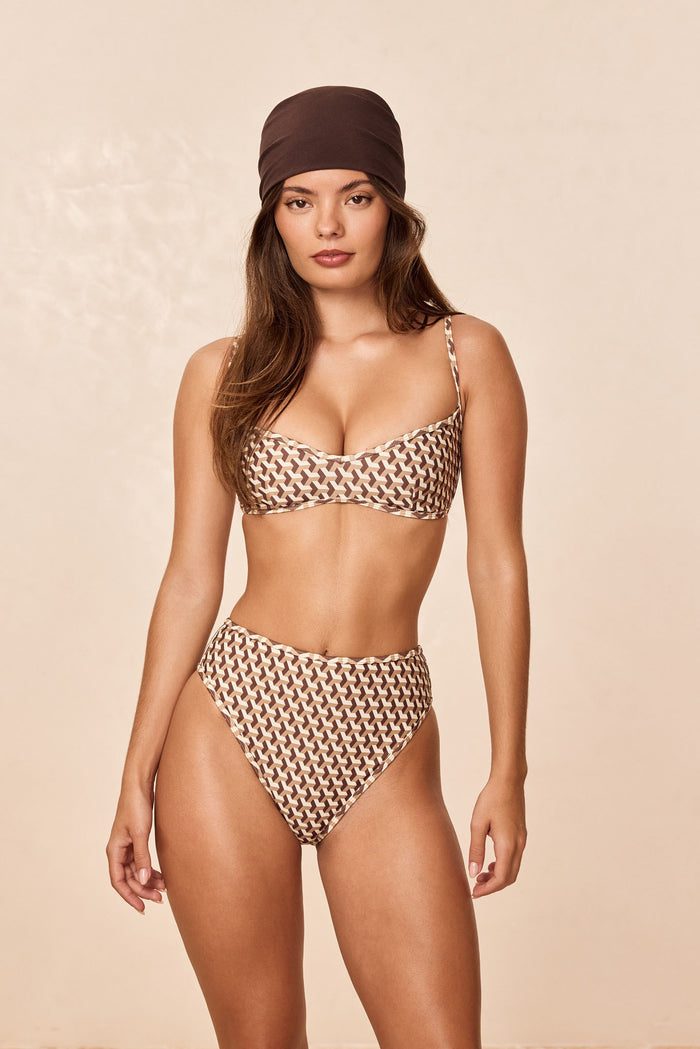 Front view of Ravello Top in Husk Geo showing balconette shape and thin adjustable straps on model, beige background