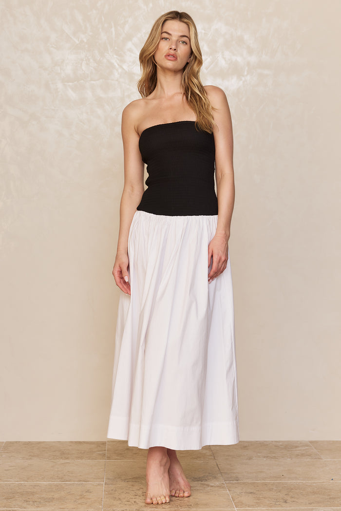 Front view of Rio Dress in White/Black with strapless smocked black bodice and full white maxi skirt on neutral background