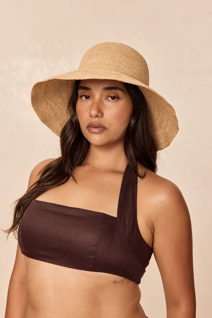 Front view of Rio Hat in Natural raffia on model showing wide 4.25-inch brim, packable shape, neutral beige background