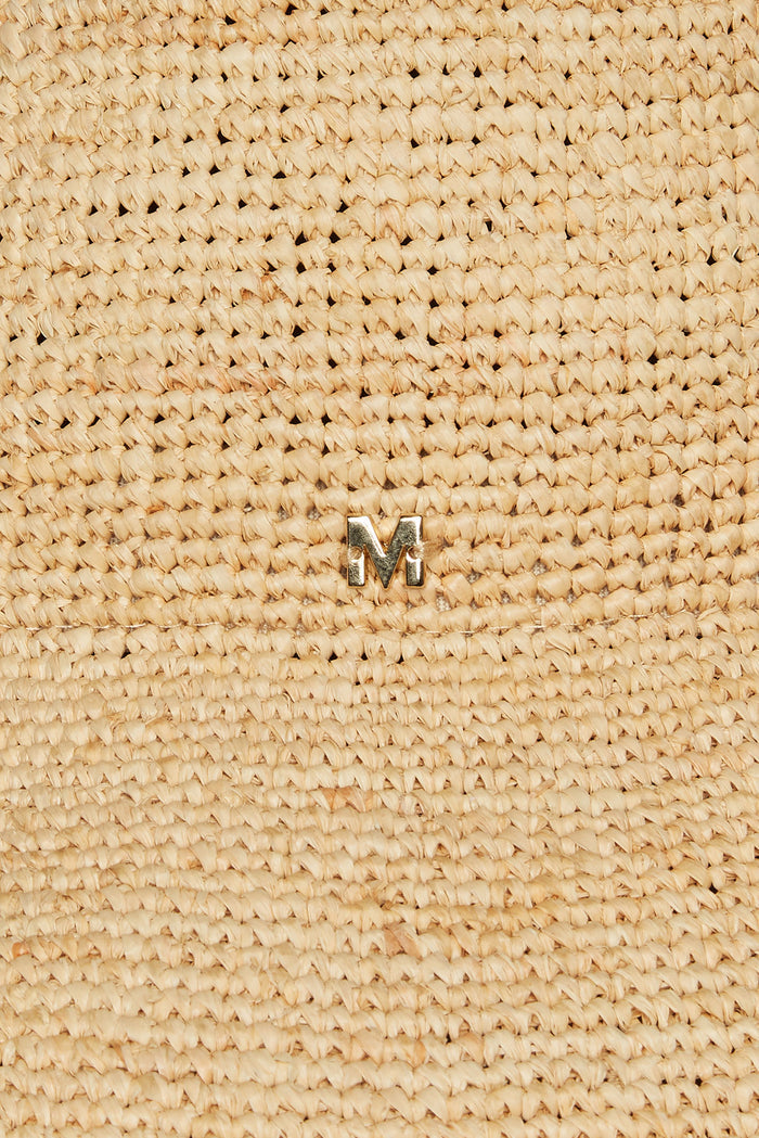 Close-up of Rio Hat in natural raffia showcasing woven texture and small gold M logo