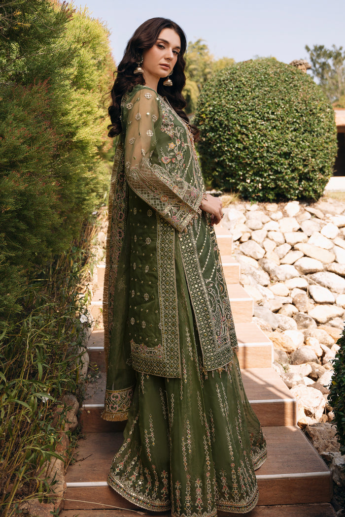 Side view of NAQSHI Ruhiya olive green outfit showing long embroidered shirt, sharara flare, sleeve hangings, and soft organza dupatta.