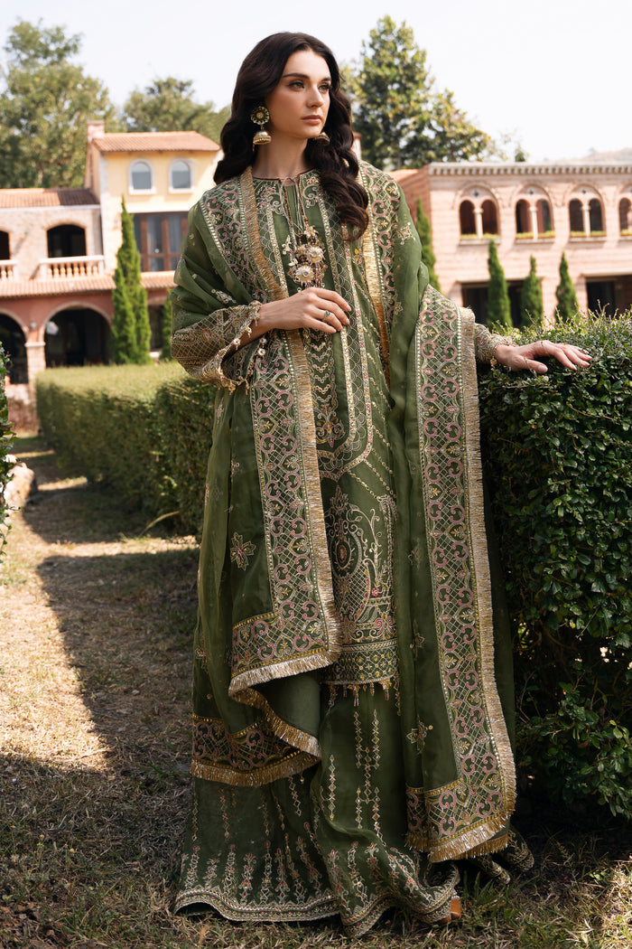 Walking view of NAQSHI Ruhiya olive green organza outfit showing sharara movement, flowing dupatta, and polished event-ready look.