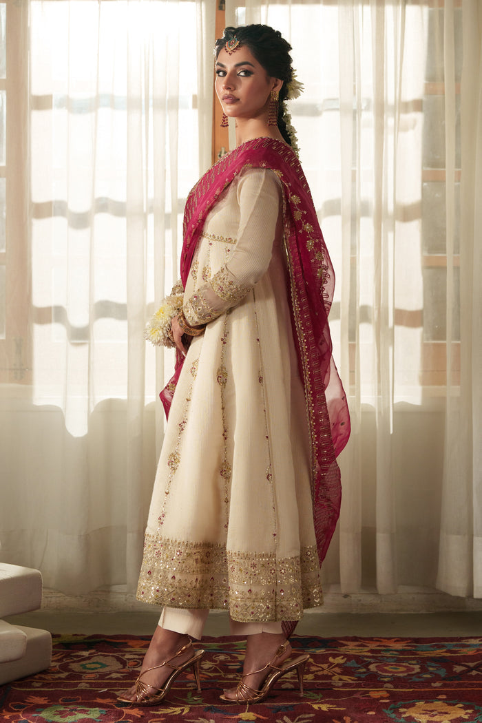 Side profile of NAQSHI Rumi showcasing fluid viscose frock cut, tailored sleeves, front slit, and matching PK raw‑silk trouser silhouette