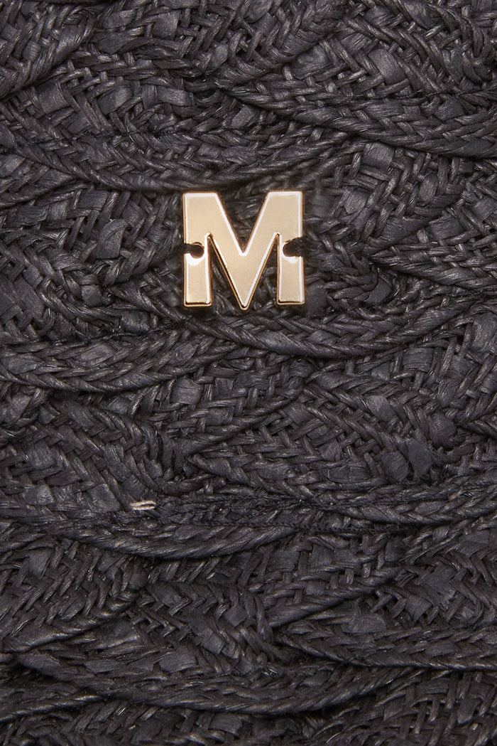 Close-up of San Remo Hat in black showcasing gold M logo on braided paper raffia