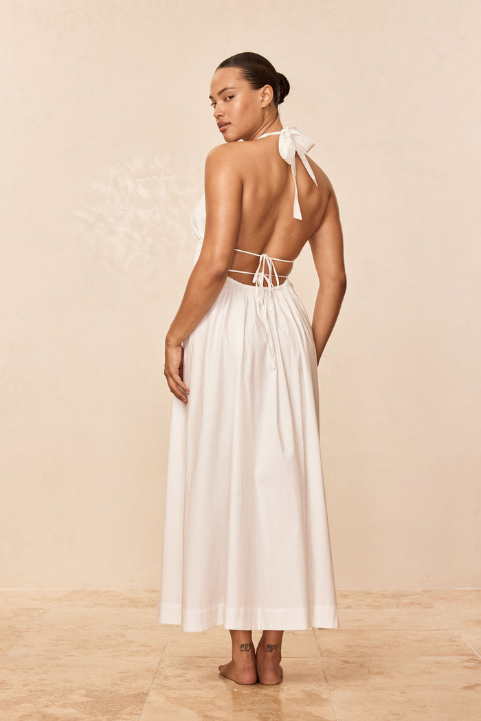 Back view of Santa Cruz Dress in white with halter tie, open back with adjustable ties and ankle-length skirt