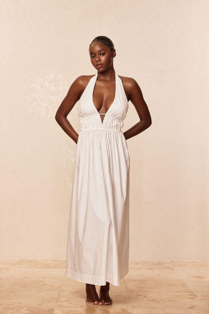 Front full-length view of Santa Cruz dress in white on model, plunging halter V neckline, gathered elastic waist, ankle-length