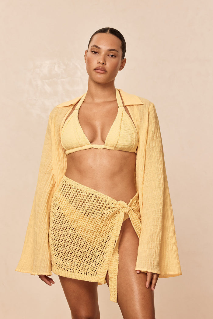 Front view of Santa Marta sarong in Honey petit crochet showcasing side-tie wrap and open crochet knit on a model against a neutral beige backdrop