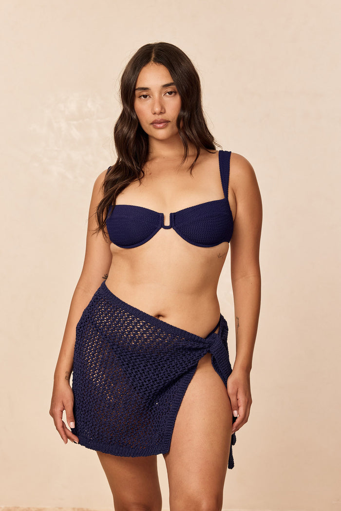 Front of Santa Marta Sarong in Midnight Petit Crochet showing crochet knit, hip tie and high side slit on neutral background
