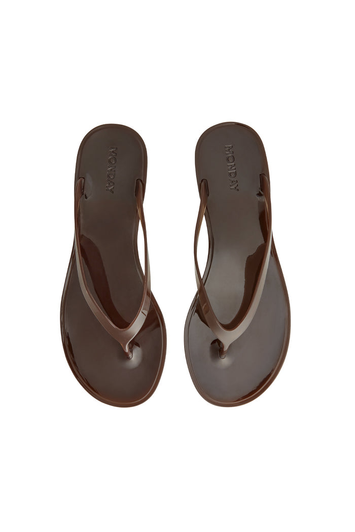 Top view of Sardinia Sandal in espresso showing glossy jelly straps and debossed MONDAY logo on a white background