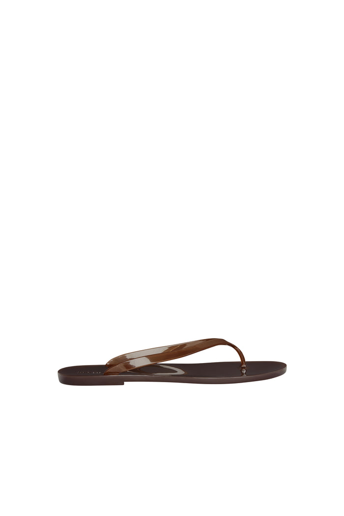 Side view of Sardinia Sandal in espresso showcasing glossy jelly flip-flop straps and flat low-profile sole on white background