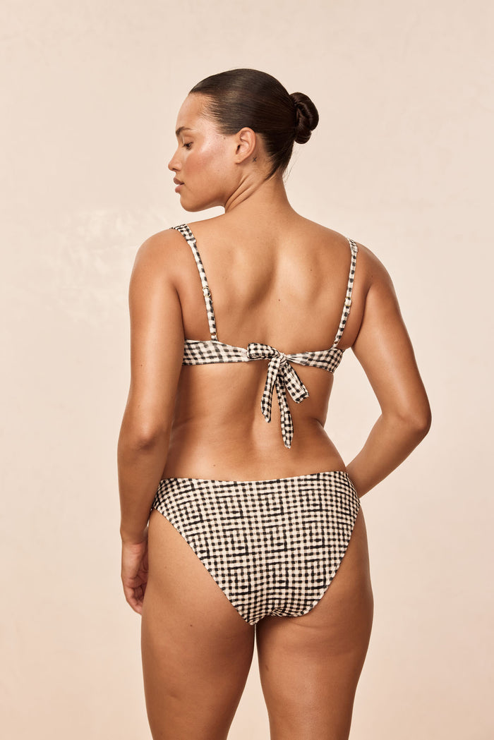 Rear view of Seychelles Bottom in black gingham showing mid-rise coverage and matching tie-back top on beige background
